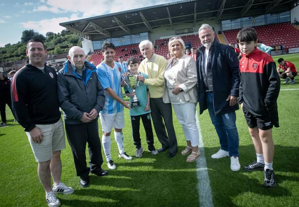 Phoenix Athletic captain Declan Harley receives the D&D SmartPAYni Jimbo Crossan Memorial Cup from Jobby Crossan at the Brandywell on Saturday afternoon. (Photos: Jim McCafferty Photography)