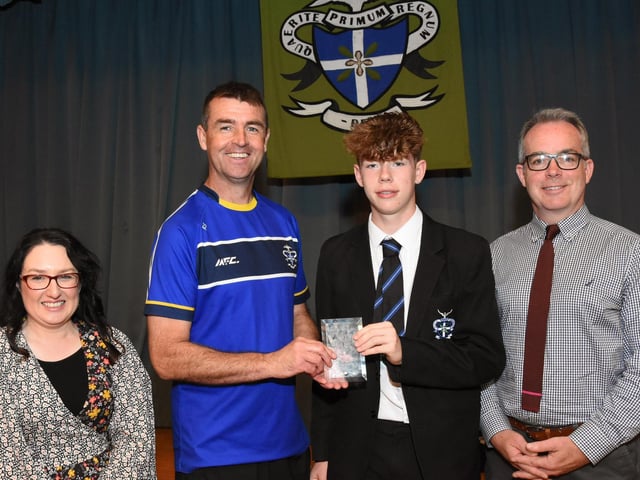Year 8 Overall Sportsman of the Year 2022-2023, Jay McCafferty 8B receiving his award from Mr. E. Burns, Head of PE. On left is Mrs C McLaughlin, Vice Principal, and on right, Mr T McGonigle, Senior Teacher.