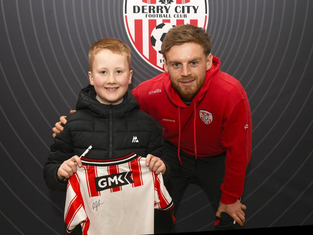 Candystripe fan Cian Maguire pictured with Derry City's Rob Slevin at the club's merchandise outlet in Foyleside Shopping Centre. Photo: George Sweeney
