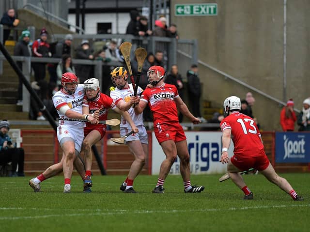 Tyrone and Derry players contest a loose sliothar. Photo: George Sweeney