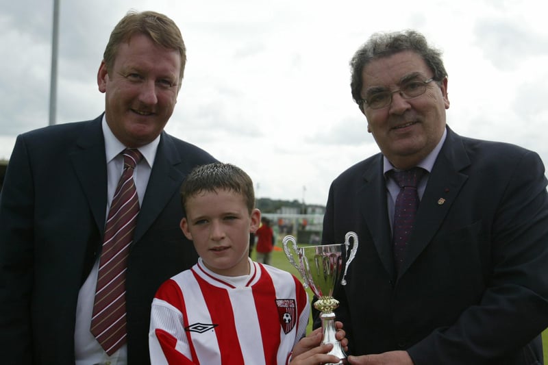 John Hume, MEP, presenting Derry & District under 12 captain Sean Devlin with the trophy his side won in the pre Barcelona game against an FAI selection. Included in Derry city chairman Jim Roddy. (1508JB16)