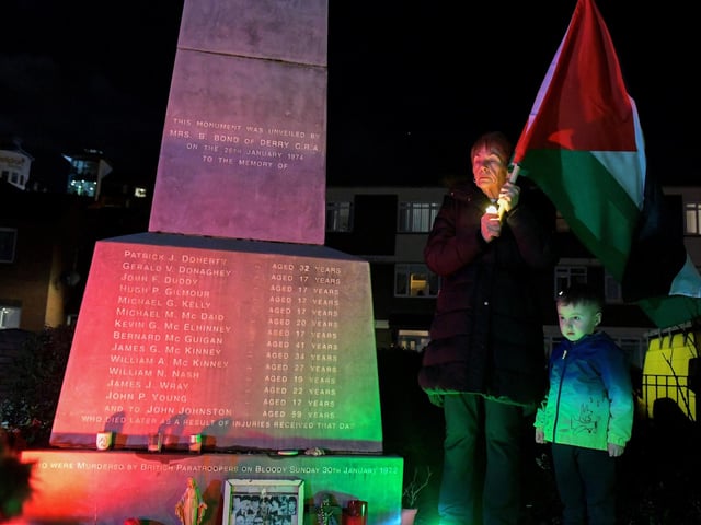 Participant holds a Palestinian flag at the procession and vigil for the children of Palestine at the Bloody Sunday Monument on Rossville Street. Photo: George Sweeney