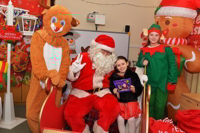 Maise pictured with Santa and his helpers at the Galliagh Community Christmas Craft Fair and Wonderland on Saturday afternoon.  Photo: George Sweeney