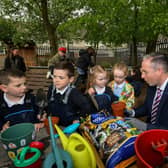 Education Minister Paul Givan pictured in the Rang 1 garden with pupils during his visit to the  Naíscoil Dhoire and Bunscoil Cholmcille, Steelstown, on Wednesday morning. Photo: George Sweeney