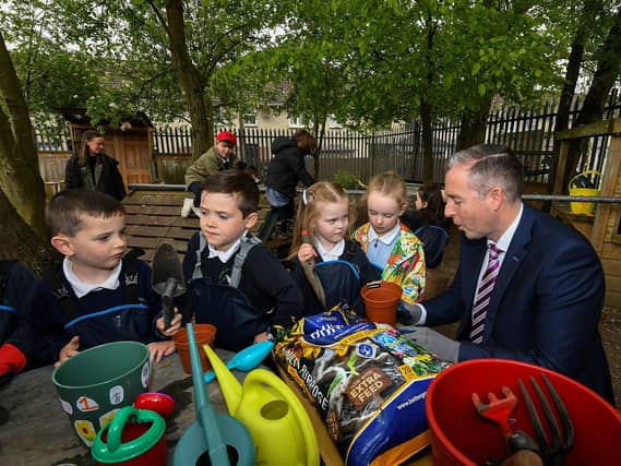 Education Minister Paul Givan pictured in the Rang 1 garden with pupils during his visit to the Naíscoil Dhoire and Bunscoil Cholmcille, Steelstown, on Wednesday morning. Photo: George Sweeney