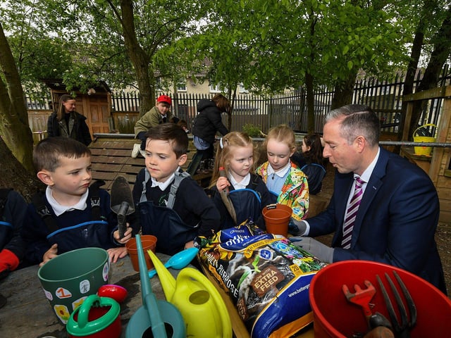 Education Minister Paul Givan pictured in the Rang 1 garden with pupils during his visit to the Naíscoil Dhoire and Bunscoil Cholmcille, Steelstown, on Wednesday morning. Photo: George Sweeney