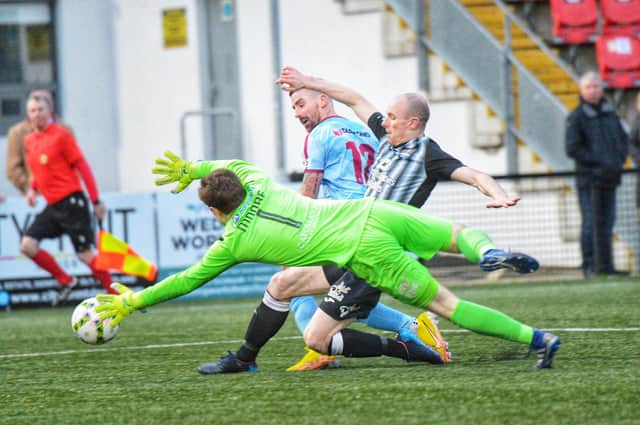 Calvin McCallion attempts to get to this ball as Ards keeper Alex Moore comes to claim. Photo by George Sweeney.