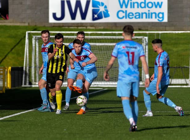 Institute’s Shaun Doherty gets the ball before H&W Welders’ Matthew Ferguson.