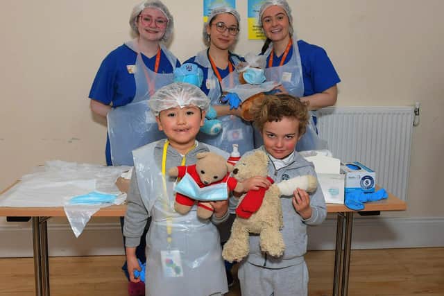 Ulster University medical students Seánna Gregory, Tatyana Sinaisky and Emily Duffin pictured with pupils at the Teddy Bear Hospital event held in the Model Primary on Wednesday morning. Photo: George Sweeney