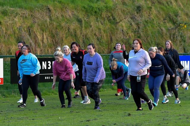 Warm-up exercises ahead of Doire Trasna’s first Mothers and Others football practice session, at Corrody Road. Photo: George Sweeney. DER2316GS – 11