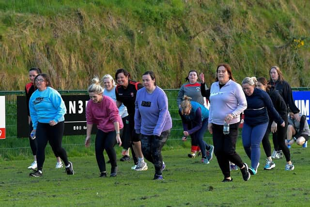 Warm-up exercises ahead of Doire Trasna’s first Mothers and Others football practice session, at Corrody Road. Photo: George Sweeney.  DER2316GS – 11