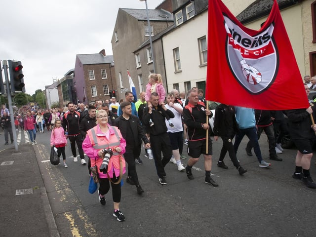 The referees carry the Foyle Cup banner on their way through the city.
