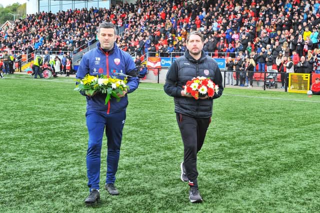 Derry City manager Ruaidhri Higgins and Treaty United boss Tommy Barrett lay a wreath in memory of the 10 people who lost their lives in Creeslough.