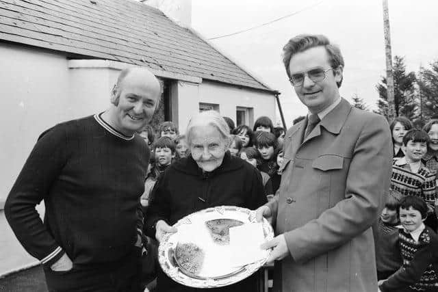 The late Dinny McLaughlin, on left, with Mr. Pat Hughes, principal of Scoil Cholm Cille, Ballymena, Malin, presenting an inscribed silver salver to Mrs. Mary Collins of Beaugh, Malin, on the occasion of her 104th birthday in March 1981.