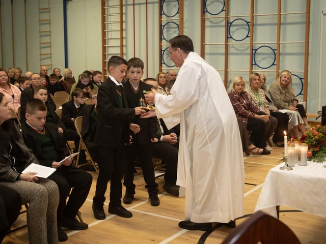 Year 8 students Kadhan and Conor handing over the Offertory Gifts to Fr. Shaun Doherty during Thursday's Mass in St. Joseph's.