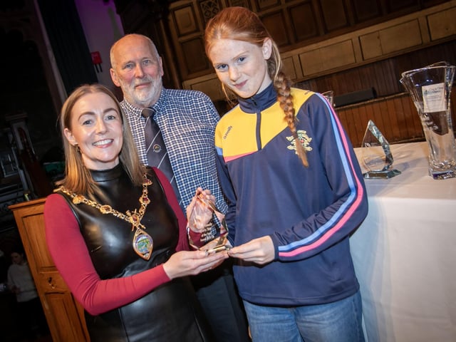 Ceola McGlinchey, winner of the Young Female Athlete award receiving her trophy from the Mayor, Grace Ui Niallais at the Annual Derry City and Strabane District Sports Awards 2026 in the Guildhall on Thursday night. Back centre is Bill Anderson, Chair, Sports Council. (Photos: Jim McCafferty Photography)