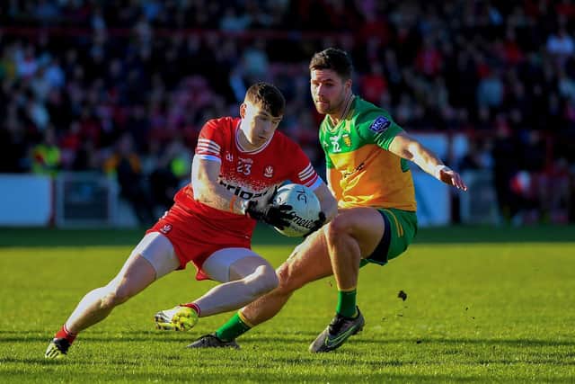 Derry’s Gareth McKinless skips a tackle from Donegal’s Brendan McCole. Photo: George Sweeney