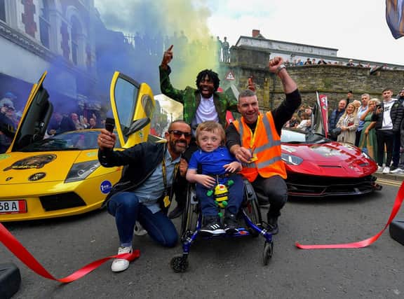 Honorary Garda Sergeant Jack Beattie from Raphoe cuts the tape for the start of the super cars Bear Run to Donegal and Inishowen from Derry’s Shipquay Street, on Saturday morning, to raise funds for Bumbleance, the Children’s Ambulance Service. Included in the photo are compere Micky Doherty, Fabu-D and Gary from The Bear Run.  Photo: George Sweeney.  DER2317GS – 123