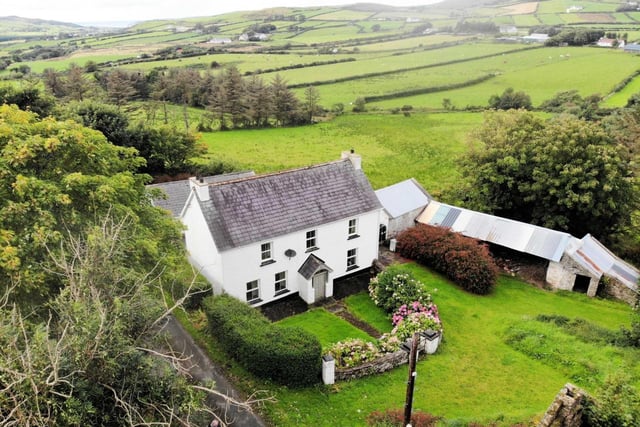 This beautifully maintained and modernised 2-storey, 3 bedroom farmhouse stands on a one acre site with Outbuildings and Sheds at Tullymore halfway between Malin Village and Malin Head only 5 minutes from Five Fingers Strand . The house which is part of an overall farm of 33 acres is being sold as a separate unit and is in excellent condition having been modernised yet retains many original features. The property, built around 80 years ago, has Bangor blue slates, pebble dash render, three spacious bedrooms, dual central heating, modern kitchen and spacious living room.