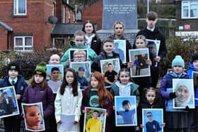 Fourteen young relatives of those murdered on Bloody Sunday carry photographs of children from the West Bank killed by the Israeli military, at the one minute silence dedicated to the children of Gaza at the Bloody Sunday monument yesterday afternoon. Photo: George Sweeney