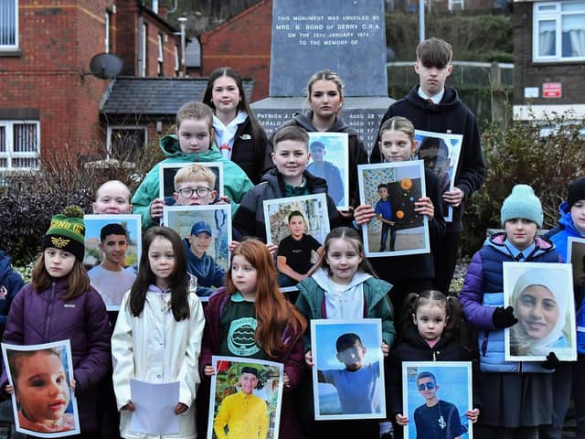 Fourteen young relatives of those murdered on Bloody Sunday carry photographs of children from the West Bank killed by the Israeli military, at the one minute silence dedicated to the children of Gaza at the Bloody Sunday monument yesterday afternoon. Photo: George Sweeney