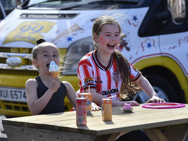 People enjoy the sunshine and the sounds of the Top Tier Brass Band playing in Meenan Square. Photo: George Sweeney