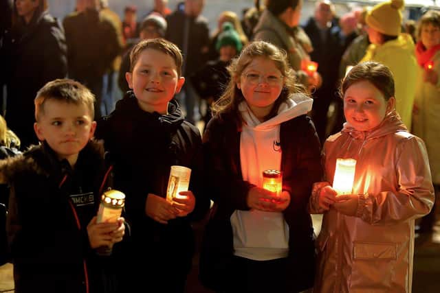 Children carry lighted candles at a vigil, held in Guildhall Square to remember those who died in the Creeslough tragedy. Photo: George Sweeney. DER2241GS – 47