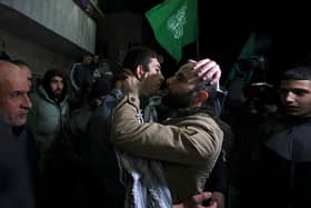 Palestinian prisoner Khalil Zama' (L) hugs a relative after being released from an Israeli jail in exchange for Israeli hostages released by Hamas from the Gaza Strip, at his home in Halhul village north Hebron in the occupied West Bank on November 27, 2023. Israel's prison service said 39 Palestinian detainees were released on November 26, 2023 under the terms of a truce agreement between Israel and Hamas in the Gaza Strip. The announcement came after 13 Israeli hostages were freed in the Palestinian territory under the deal, along with three Thais and a Russian-Israeli dual citizen. (Photo by HAZEM BADER / AFP) (Photo by HAZEM BADER/AFP via Getty Images)
