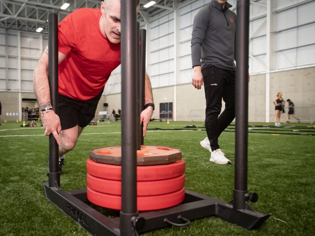Competitor Ryan Doherty gets his back into the Sled Push during Sunday's event.