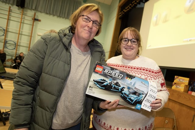 Janine Hamill picks up her prize from Lisa Grant at St. Joseph's Boys School Annual Christmas Rickety Wheel on Thursday night at the school. 