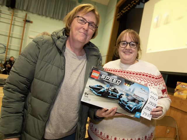 Janine Hamill picks up her prize from Lisa Grant at St. Joseph's Boys School Annual Christmas Rickety Wheel on Thursday night at the school.