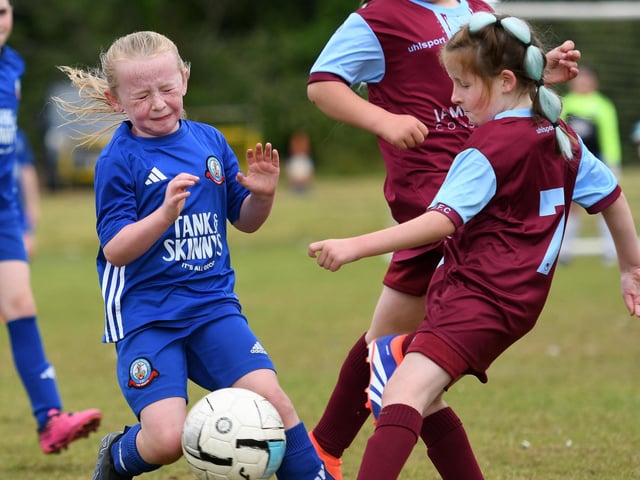 Lily Patterson, Newbuidings United, clears her lines under pressure from Buncrana Hearts forward Carrie King during their girls under-9's match.