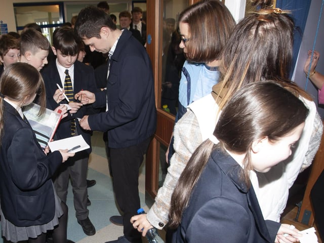 Damian signing autographs for students at Lumen Christi College on Tuesday.