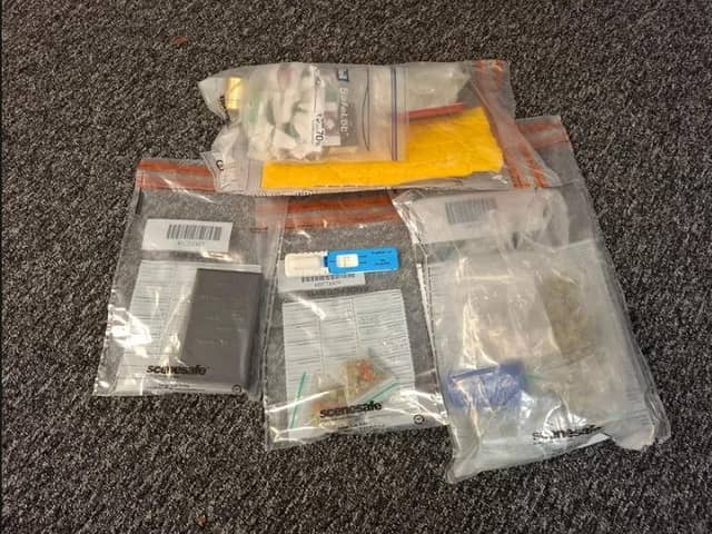 Suspected drugs and items seized along with the drug-detection kit, which is pictured in the middle of the picture, coloured blue and white.