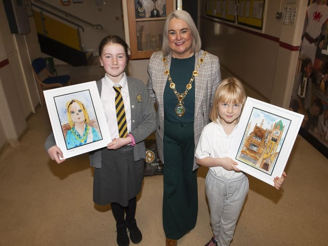 Eve and Aoife presenting the Mayor, Sandra Duffy with a portrait of herself and a portrait of the Guildhall during Monday’s visit to the Model PS.