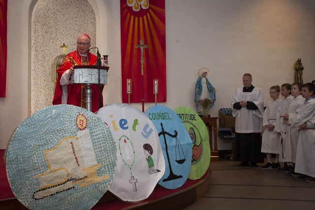 Some of the artwork on display from the various schools is displayed at the front of the altar as Bishop Donal McKeown addresses the schoolchildren.