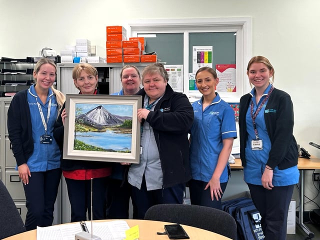 The Western Health and Social Care Trust (Western Trust) acknowledges a kind donation from local artist Mrs Jean Mulhern from Feeny of a beautiful painting of Mount Errigal, Co Donegal which was presented to the Hospital at Home Team, Ward 5, Waterside Hospital, Derry. Sr Maire O’Hara, Hospital and Home Team Manager said: “This painting will be displayed in the Hospital at Home purpose built building which the Team have moved into earlier this year. It is such a wonderful gesture and we would like to thank Jean for her generosity.” Hospital at Home Team staff pictured from left to right: Staff Nurse Niamh McLaughlin; Sr Maire O’Hara; Staff Nurse Edel Barr; Nursing Assistant Geraldine McElhinney; Staff Nurse Robin King and Staff Nurse Claire McGonagle.