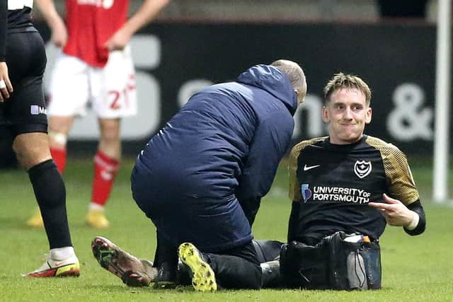 Not good news as Portsmouth midfielder Ronan Curtis (11) signals for the substitution.