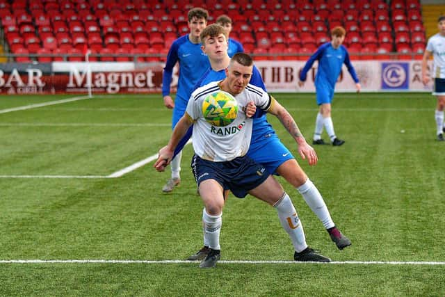 UU Magee captain Shea Ferguson holds the ball up against South West College.