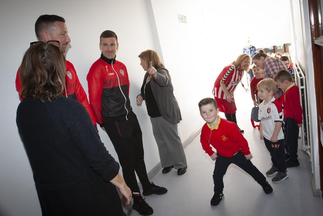 One young Steelstown pupil shows some nifty footwork of his own to Derry City players Shane and Patrick McEleney and Michael Duffy on Tuesday. (Photo: Jim McCafferty)