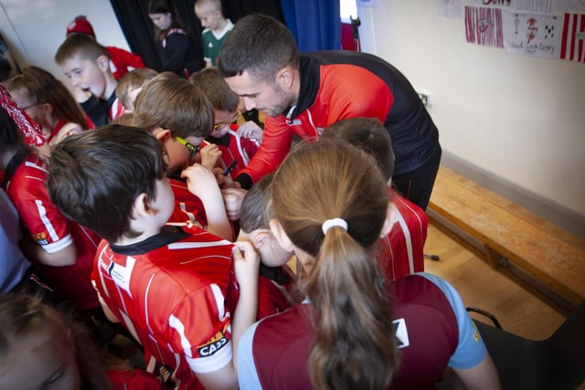 Young Derry City fans get their shirts signed by Michael Duffy during his visit to Steelstown Primary School on Tuesday. (Photo: Jim McCafferty)
