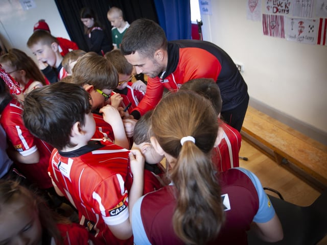 Young Derry City fans get their shirts signed by Michael Duffy during his visit to Steelstown Primary School on Tuesday. (Photo: Jim McCafferty)