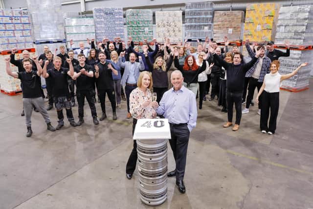 CHEERS TO 40 YEARS: United Wines Managing Director Martin McAuley and Sales Administrator Helena Smith celebrate 40 years of success in Northern Ireland with staff at the company’s warehouse in Craigavon.