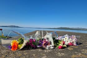 Flowers left in memory of Emmanuel Familola and Matt Sibanda at Ned's Point in Buncrana.