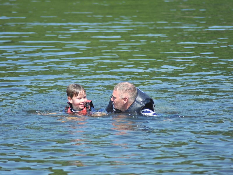 Tony Edgar swims back to shore with a five-years-old participant