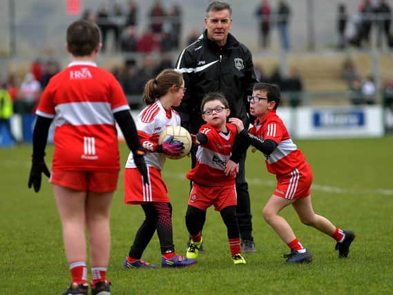 ARE YOU WATCHING, RORY? Some of the children who took part in a football game during half-time at Owenbeg on Sunday. Photo: George Sweeney. DER2312GS – 32