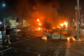 Flames rise from a car and a bus, set alight at the junction of Bachelor's Walk and the O'Connell Bridge, in Dublin on November 23, 2023, as people took to the streets following the stabbings earlier in the day. Protesters in Dublin on Thursday torched a car and fought police, an AFP journalist reported, after three children were injured in a suspected school stabbing that social media rumours attributed to a foreign national. (Photo by Peter MURPHY / AFP) (Photo by PETER MURPHY/AFP via Getty Images)