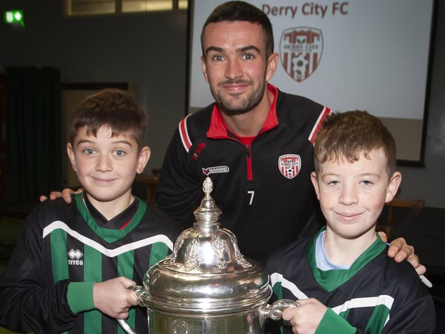 Derry City FC’s Michael Duffy pictured with Greenhaw PS school football team captains Kian and Isaac.