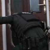 A police officer enters a property as part of Operation Pangea.