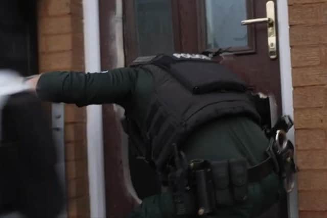 A police officer enters a property as part of Operation Pangea.